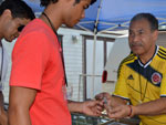 Mr. Cortez of Ruby's Jewelry assists jewelry shoppers at the American German Club celebrating Colombian Independence Day